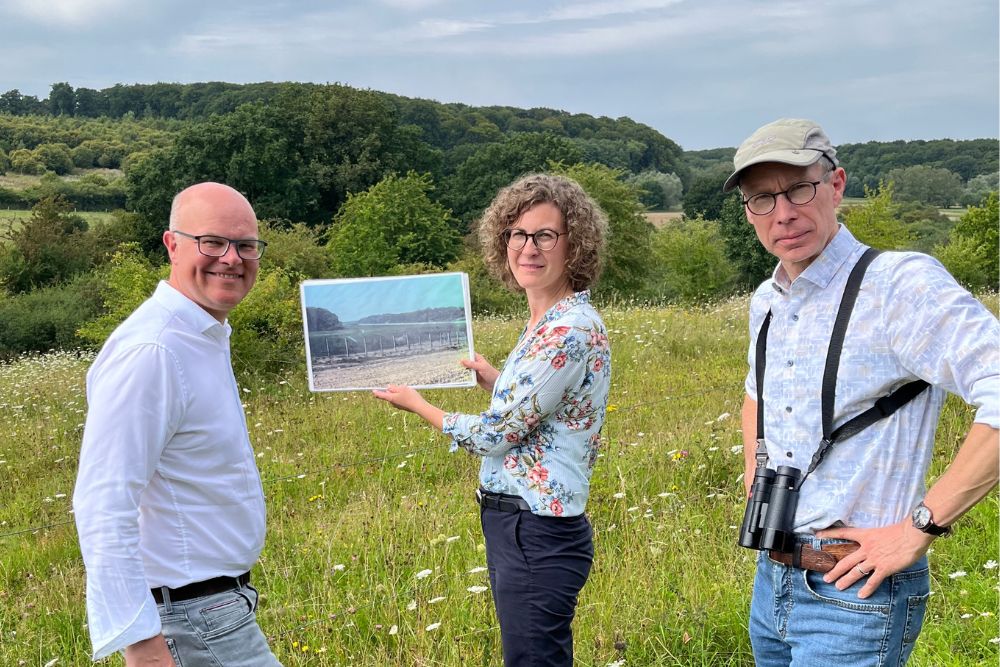 Tobias Goldschmidt (Umweltminister des Landes Schleswig-Holstein), Maria Boness (Geschäftsstellenleiterin des Zweckverbands Schaalsee-Landschaft) und Manfred Bohlen (Leiter des Referats Schutzgebiete und Artenschutz des Ministeriums für Energiewende, Klimaschutz, Umwelt und Natur des Landes Schleswig-Holstein) stehen vor den Kieckbuschweisen an der ehemaligen innerdeutschen Grenze bei Mechow und schauen sich die heutige Situation im Vergleich zum Zeitpunkt der Wiedervereinigung (1991) an
